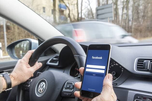 Mann, Autofahrer, benutzt ein Handy, während der Fahrt, Facebook Login Seite,