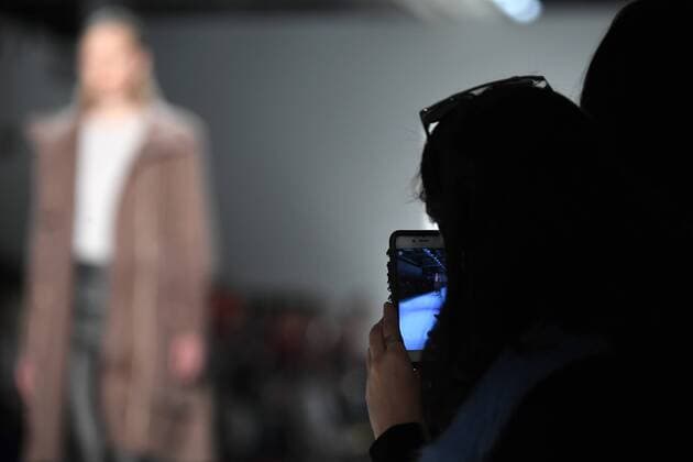 An audience member takes a photo of a model on the runway with her cell phone at the Marcel Ostertag fashion show at New York Fashion Week: The Shows at Gallery 3 Skylight Clarkson Sq on February 12, 2017 in New York City.  NYP20170212903 ANDREAxHANKS