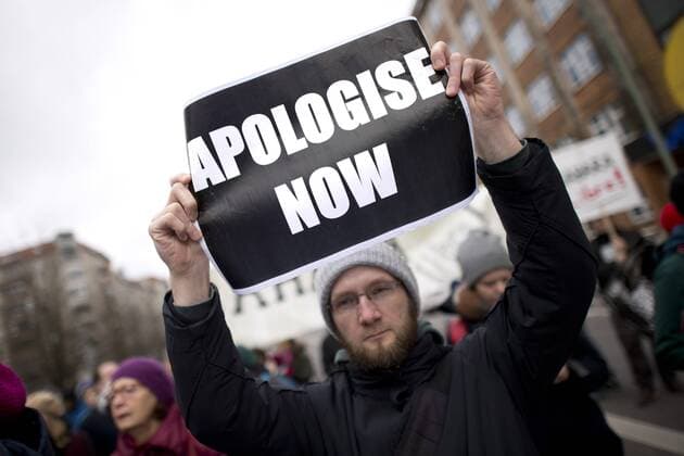 Gedenkmarsch Kolonialgeschichte DEU, Deutschland, Germany, Berlin, 25.02.2017 Demonstranten mit Plakat Apologise now, Entschuldigung sofort, beim 11. Gedenkmarsch zur Erinnerung an die afrikanischen Opfer von Versklavung, Kolonialismus und rassistischer Gewalt vom Komitee fuer ein afrikanisches Denkmal in Berlin und afrikanischer Vereine in Berlin. Dieser Gedenkmarsch wurde ins Leben gerufen, um der Forderung nach Anerkennung der Verbrechen gegen Schwarze Menschen und Menschen afrikanischer Herkunft Nachdruck zu verleihen. Anlass ist die Berliner Afrika-Konferenz von 1884 - 1885, auf der Afrika vor 130 Jahren unter den europaeischen Kolonialmaechten aufgeteilt wurde. Mehr als 30 Millionen Afrikanerinnen und Afrikaner wurden Opfer von Versklavung und kolonialen Verbrechen gegen die Menschlichkeit. Die von Deutschland an den Herero und Nama begangenen Voelkermorde in Namibia und die Kriegs