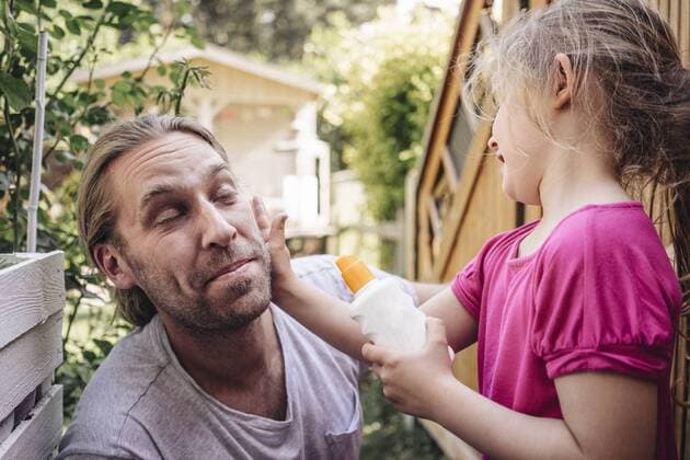 IMAGO Creative, Jahreszeit Sommer, Sonnenschutz Daughter applying sunscreen on father s face in garden model released Symbolfoto property released  JOSF00585