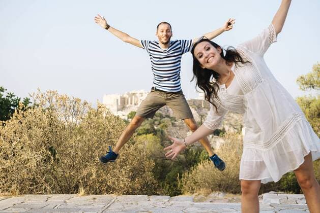 Greece, Athens, happy couple jumping at Areopagus with The Acropolis and Parthenon in the background model released Symbolfoto  GEMF01430