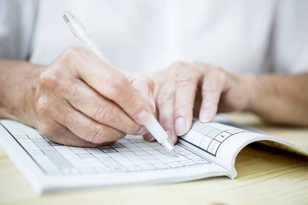 Close-up of senior woman doing a crossword puzzle model released Symbolfoto  WESTF22677