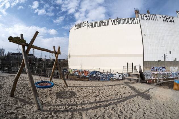ZWANGSRÄUMUNGEN VERHINDERN steht an einer Hausfassade vor einem Spielplatz an der Behmstrasse zwischen den Berliner Stadtteilen Wedding und Prenzlauer Berg ZWANGSRÄUMUNGEN VERHINDERN