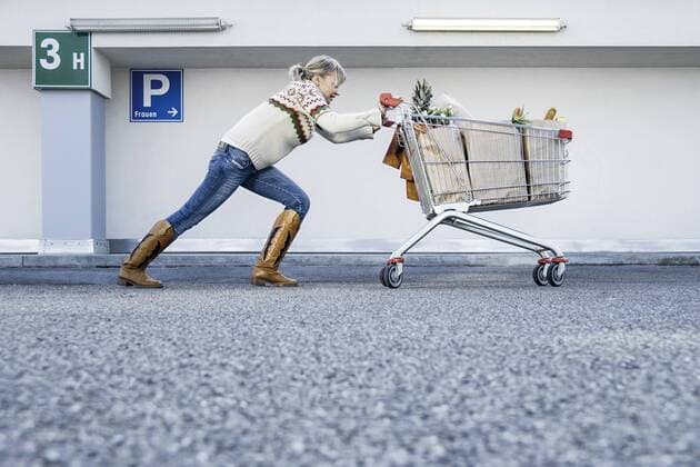 Frau schiebt angestrengt einen vollen Einkaufswagen (model-released) Copyright: xMEVx ALLMVAID013FR08