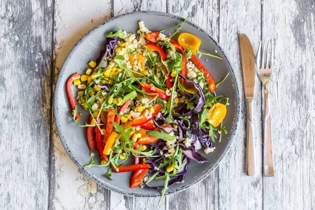 Glass of rainbow salad with bulgur, rocket and different vegetables and bowls with ingredients  SARF03238