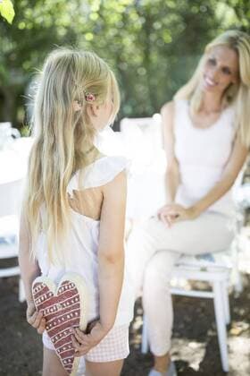 Daughter hiding heart behind her back looking at mother model released Symbolfoto  WESTF22793