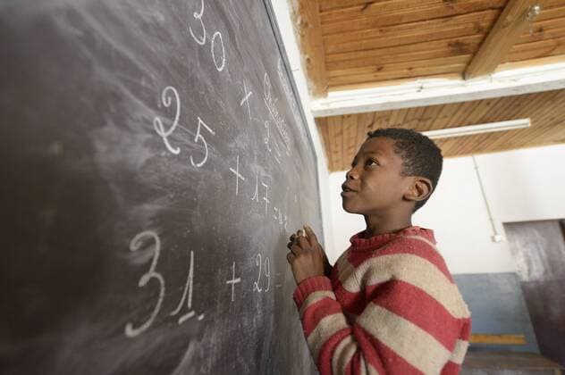 Madagaskar, Boy in Fianarantsoa elementary school calculatiing at blackboard model released Symbolfoto  FLKF00758