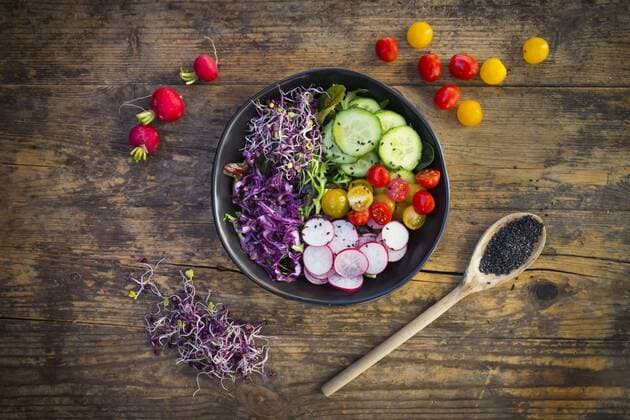 Lunch bowl of organic leaf salad, red cabbage, tomatoes, cucumber and radish sprouts  LVF05939