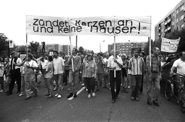 Rostock - 29.08.1992 tausende Menschen demonstrieren gegen die rassistischen Übergriffe auf Asylantenheime. Das Sonnenblumenhaus in Rostock-Lichtenhagen wurde von rechten und betrunkenen Randalierern in Brand gesteckt. Auf einem Transparent steht : Zündet Kerzen an und keine Häuser !