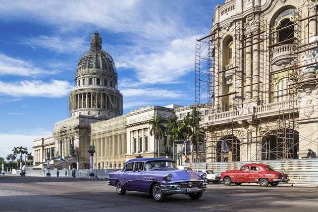 A pair of colourful old timers travel in opposite directions in front of El Capitolio in Havana. Copyright: xJasonxWells LOOPxIMAGESx JWS20016WT11