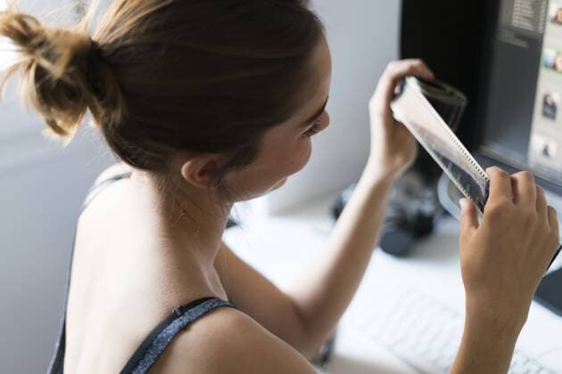 Female photographer editing images at desk model released Symbolfoto  KKAF00590