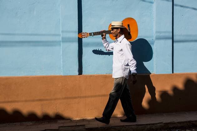 Cuba, man with guitar walking on the street model released Symbolfoto  MAUF01037