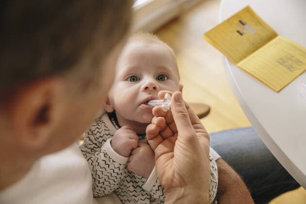 Three-month-old baby receiving oral vaccination model released Symbolfoto  MFF03482