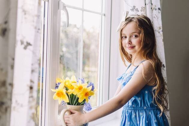 Portrait of smiling girl with flower vase of daffodils and hyacinths at home model released Symbolfoto property released  NMSF00043