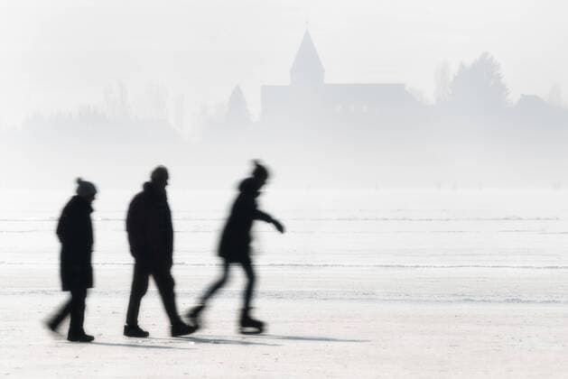 Germany, Lake Constance, Hegne, silhouettes of ice skater and walkers in front of St George s Church at Reichenau  SHF01951