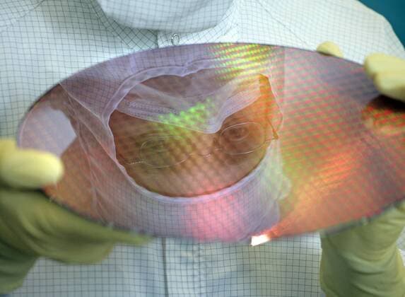 Mitarbeiter im Reinraumanzug mit 300 mm Wafern bei AMD Dresden . In den Halbleiterwerken FAB 30 und FAB 36 werden Mikroprozessoren auf 200 und 300 mm Wafer hergestellt . Advanced Micro Devices (AMD) . Dresden , 24.10.2006 , , , Dresden Deutschland Copyright: xThomasxKoehxlerx