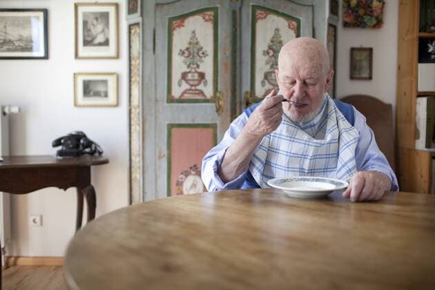 77 Jaehriger mit Latz am Esstisch. Heidelberg, Deutschland. 23.03.2012. 77-year-old men sitting at the dining table waring a bib. Heidelberg, Germany. 23.03.2012 . MODEL RELEASE vorhanden, MODEL RELEASED . Heidelberg Deutschland Copyright: xUtexGrabowskyx