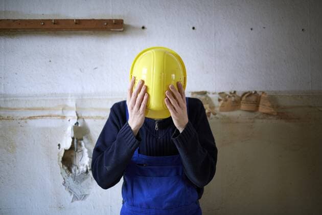 Ein Bauarbeiter haeält sich seinen Arbeitsschutzhelm vor das Gesicht, um nicht erkannt zu werden, Baustelle in Berlin. (gestelltes Foto), Berlin, 03.02.2016. MODEL RELEASE vorhanden, Model release available, MODEL RELEASED. Berlin Deutschland Copyright: xThomasxKoehlerx