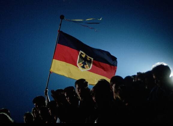 Menschen waehrend der Deutschen Wiedervereinigung mit einer Deutschen Flagge. Berlin den 03.10.1990, Â Berlin Deutschland Copyright: xThomasxImox