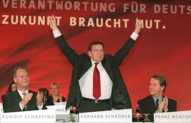 SPD-Parteichef Bundeskanzler Gerhard Schroeder laesst sich nach seiner Grundsatzrede von den Delegierten feiern . Links Bundesverteidigungsminister Rudolf Scharping, SPD, rechts der SPD-Generalsekretaer Franz Muentefering. SPD-Parteitag in Berlin. 07.12.1999 , Berlin Deutschland Copyright: xNicolexMaskusx