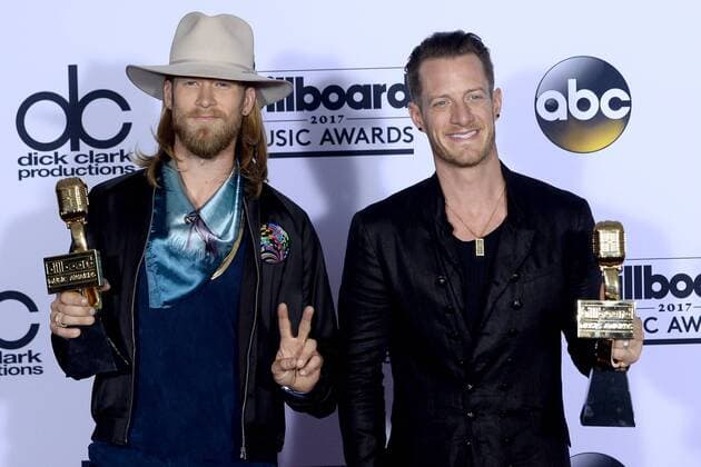 Recording artists Brian Kelley (L) and Tyler Hubbard of music group Florida Georgia Line appear backstage with their Top Country Song award for H.O.L.Y., during the annual Billboard Music Awards held at T-Mobile Arena in Las Vegas, Nevada on May 21, 2017. This year?s show will air live on both coasts at 8 p.m. ET on ABC.  LAV201705211009 JIMxRUYMEN