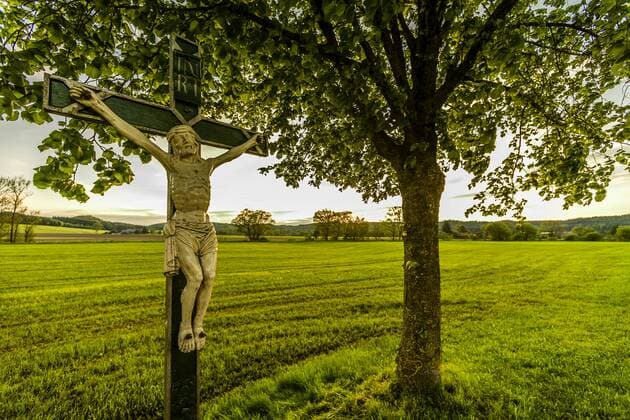 Eine Heiligenfigur steht an einer kleinen Strasse von Aichstetten nach Aitrach, Leutkirch, Baden Württemberg, Deutschland Wegkreuz bei Aichstetten