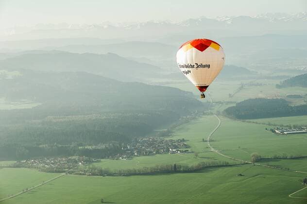 Ein Heissluftballon fährt in den frühen Morgenstunden über die Allgäulandschaft bei Friesenhofen, Baden Württemberg, Deutschland. Bei einer Fahrt mit dem Heissluftballon über das Allgäu zwischen Wangen und Leutkirch.