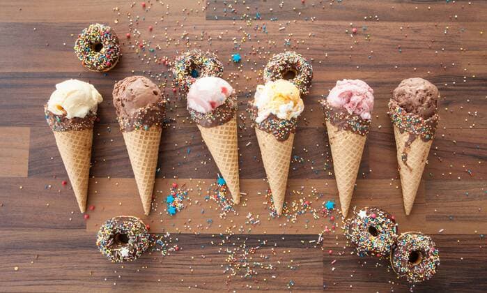 Eiscreme in Waffeltüten mit Schokolde und Zuckerstreuseln  1079704259