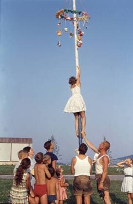 Junge Frau die an einem Maibaum hochklettert GER, 19580501, Junge Frau die an einem Maibaum hochklettert