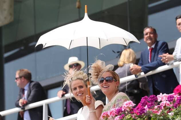 . 21 06 2017. Ascot , United Kingdom. Two race goers use a parasol to keep cool during the hot weather on day two of Royal Ascot in Berkshire, United Kingdom.  xStephenxLockx xi-Imagesx IIM-15424-0016