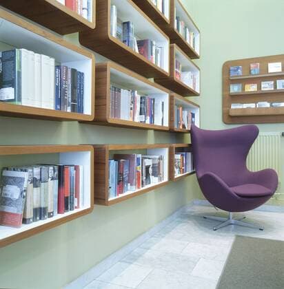 Designklassiker von Arne Jacobsen Liebeskind Publishers Bookshop, Munich Germany. Chair by shelves in corner of room. Architect: Uli Tredup and Bettina Hamann Bavaria Germany  Copyright: xJamesxBalstonx 31001-20-1