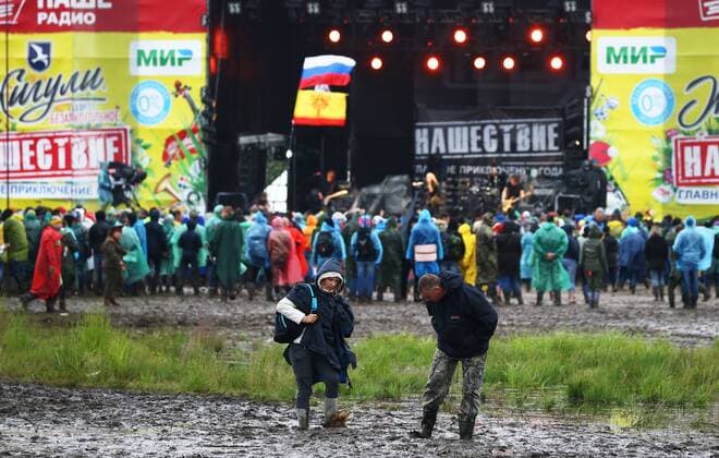 TVER REGION, RUSSIA â€“ JULY 8, 2017: Festival-goers in rainscoats walk through mud at the 2017 Nashestvie open air rock music festival. Alexander Ryumin TASS  TS056966