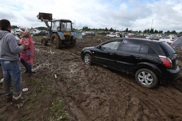 TVER REGION, RUSSIA â€“ JULY 9, 2017: A tractor pulls a car through mud at the 2017 Nashestvie open air rock music festival. Alexander Ryumin TASS  TS056AD4