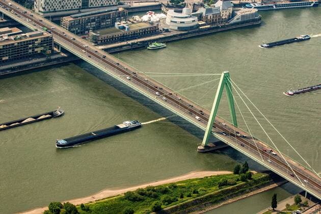 Schiffe auf dem Rhein fahren unter der Severinsbrücke her. Frachtschiffe, Binnenschifffahrt.
