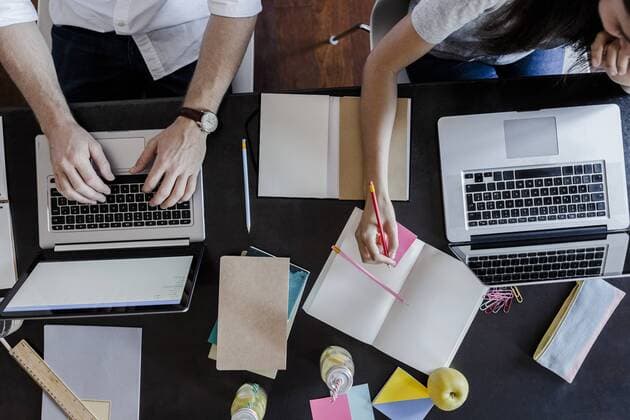 Top view of man and woman using laptops and taking notes model released Symbolfoto  GIOF02855