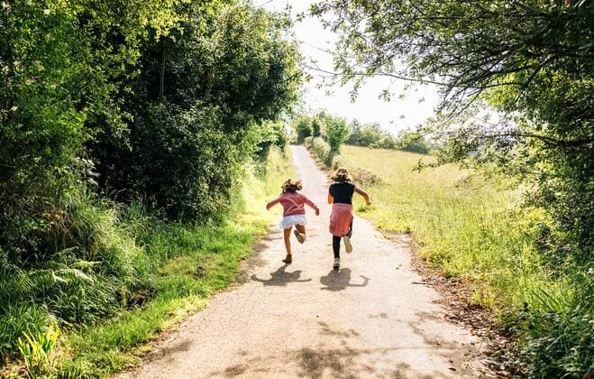 Two little girls running down a lane outdoors model released Symbolfoto  MGOF03427