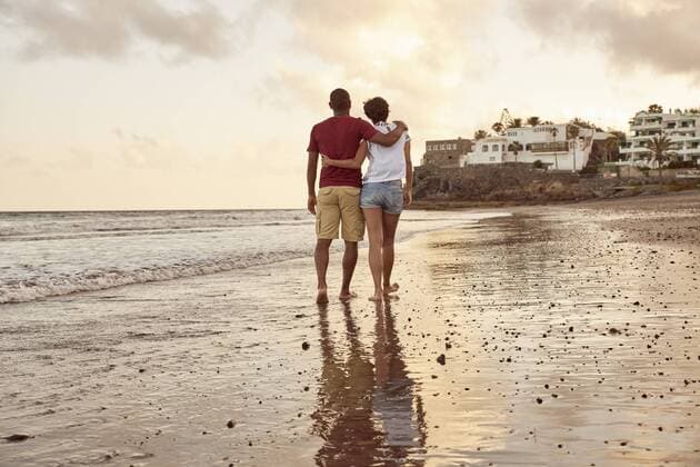 IMAGO Creative: Sommer, Abendspaziergang Spain, Canary Islands, Gran Canaria, back view of couple in love walking on the beach model released Symbolfoto  PACF00011
