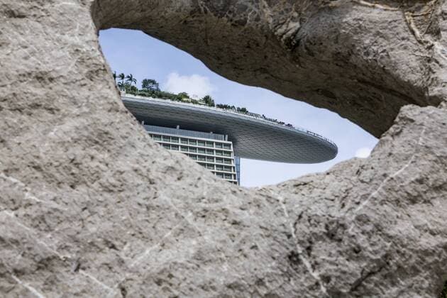 Sicht durch ein Loch in einem Stein auf den Dachgarten des Marina Bay Sands Hotel, Singapur  1082500971