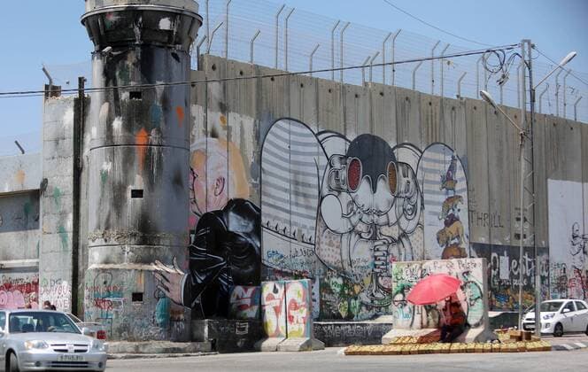 August 6, 2017 - Bethlehem, West Bank, Palestinian Territory - A Palestinian vendor sells vegetables in front of a graffiti depicting US President Donald Trump on the controversial Israeli separation barrier in the West Bank town of Bethlehem on August 8, 2017 Bethlehem Palestinian Territory - ZUMAap3_ 20170806_zaf_ap3_033 Copyright: xShadixHatemx