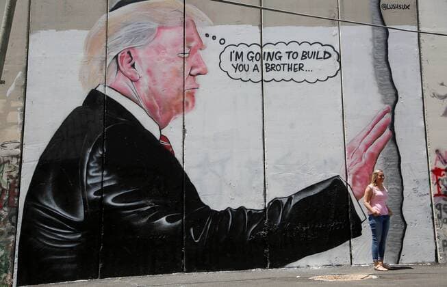 August 6, 2017 - Bethlehem, West Bank, Palestinian Territory - A tourist stand in front of a graffiti depicting US President Donald Trump on the controversial Israeli separation barrier in the West Bank town of Bethlehem on August 8, 2017 Bethlehem Palestinian Territory - ZUMAap3_ 20170806_zaf_ap3_035 Copyright: xShadixHatemx