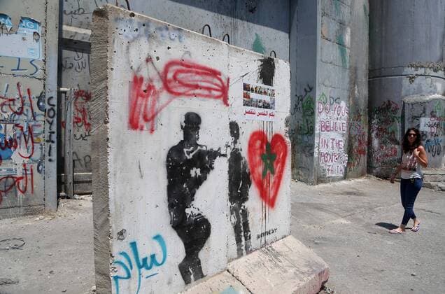 August 6, 2017 - Bethlehem, West Bank, Palestinian Territory - A tourist walks past a graffiti on the controversial Israeli separation barrier in the West Bank town of Bethlehem on August 8, 2017 Bethlehem Palestinian Territory - ZUMAap3_ 20170806_zaf_ap3_036 Copyright: xShadixHatemx