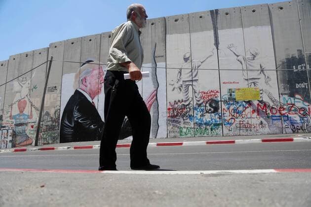 August 6, 2017 - Bethlehem, West Bank, Palestinian Territory - A Palestinian man walks past a graffiti depicting US President Donald Trump on the controversial Israeli separation barrier in the West Bank town of Bethlehem on August 8, 2017 Bethlehem Palestinian Territory - ZUMAap3_ 20170806_zaf_ap3_044 Copyright: xShadixHatemx