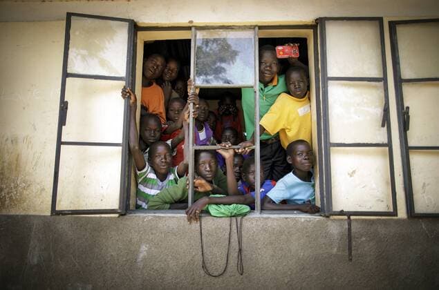 Schueler schauen aus einem offenen Fenster einer Schule im Rhino Refugee Camp Settlement im Norden Ugandas. Hier werden Kinder von Einheimischen und Fluechtlingen gemeinsam unterrichtet. In dem Gebiet leben rund 90.000 Fluechtlinge aus dem Suedsudan, Uganda, 09.08.2017. KEIN MODEL RELEASE vorhanden, NO MODEL RELEASE available, NO MODEL RELEASE. Rhino Uganda Copyright: xThomasxKoehlerx