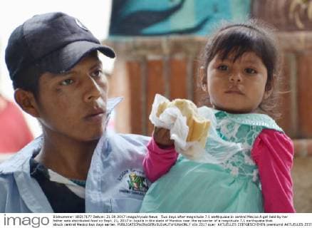 Two days after magnitude 7.1 earthquake in central Mexico A girl held by her father eats distributed food on Sept. 21, 2017 in Jojutla in the state of Morelos near the epicenter of a magnitude 7.1 earthquake that struck central Mexico two days earlier. 