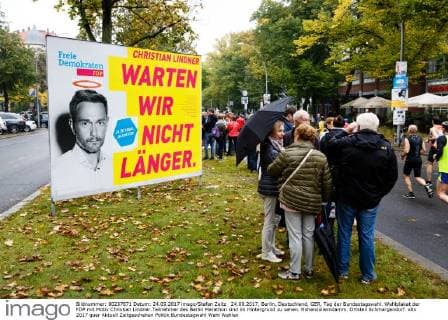 Deutsche Parteien: FDP. Wiedereinzug in den Bundestag 2017 24.09.2017, Berlin, Deutschland, GER, Tag der Bundestagswahl. Wahlplakat der FDP mit Motiv Christian Lindner.Teilnehmer des Berlin Marathon sind im Hintergrund zu sehen. Hohenzollerndamm. Ortsteil Schmargendorf.