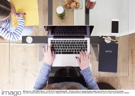 Woman typing on laptop at glass table while little girl drawing picture beside, top view model released Symbolfoto property released  IGGF00012