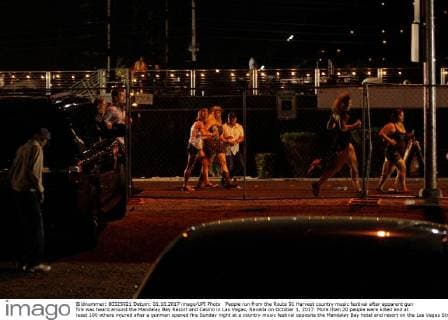 People run from the Route 91 Harvest country music festival after apparent gun fire was heard around the Mandalay Bay Resort and Casino in Las Vegas, Nevada on October 1, 2017. More than 20 people were killed and at least 100 others injured after a gunman opened fire Sunday night at a country music festival opposite the Mandalay Bay hotel and resort on the Las Vegas Strip, authorities said.  LAV2017100204 JAMESxATOA