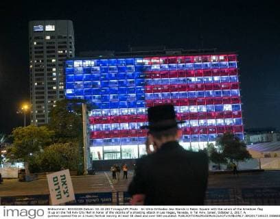 An Ultra-Orthodox Jew Stands in Rabin Square with the colors of the American flag lit up on the Tel Aviv City Hall in honor of the victims of a shooting attack in Las Vegas, Nevada, in Tel Aviv, Israel, October 2, 2017. A gunman opened fire on a music festival leaving at least 58 dead and over 500 wounded.  JER2017100223 DEBBIExHILL