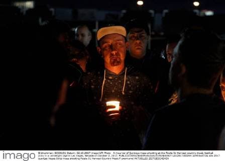 A mourner of Sundays mass shooting at the Route 91 Harvest country music festival joins in a candelight vigil in Las Vegas, Nevada on October 2, 2017.  LAV2017100244 JAMESxATOA