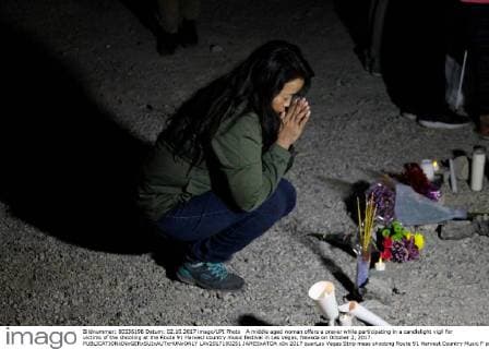 A middle aged woman offers a prayer while participating in a candlelight vigil for victims of the shooting at the Route 91 Harvest country music festival in Las Vegas, Nevada on October 2, 2017.  LAV2017100251 JAMESxATOA